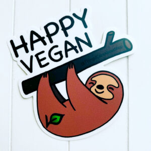 vegan magnet featuring a friendly looking sloth hanging on a branch. Above the branch, the words "Happy Vegan" are displayed in black font