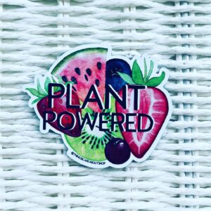 Plant Powered vegan fridge magnet featuring colourful fruits. Die cut shape. Displayed on white basket background