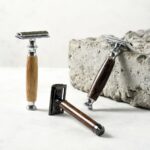 Image of 3 different bamboo handled razors with a concrete block in background