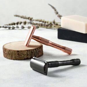 Rose gold and metallic black metal safety razors displayed with wooden slice