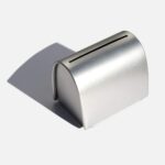 A silver tin on a white background, shaped like a small letter box with a slot in the top for putting used razors into