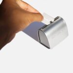 Hand placing used safety blade inside disposal tin