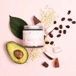 Glass jar with metal screw top lid and plantable label, displayed alongside coffee beans, half an avocado and leaves