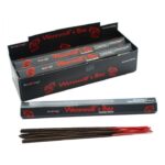 Large black display box of multiple packs of incense with one packet open displaying the black and red incense sticks inside.