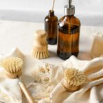 Lifestyle shot of the brushes with cloths and brown glass bottles in background